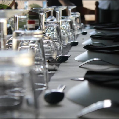 koli-detalle-mesa-servicio-evento.jpg Detalle de mesa en KOLI con copas de cristal invertidas, servilletas negras y cubiertos elegantes, preparada para un servicio especial.