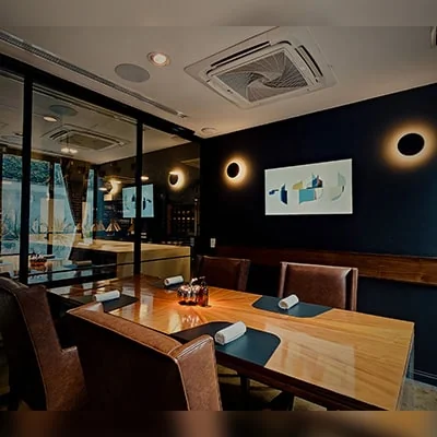mesadelchef Sala privada en KOLI, con una mesa de madera elegante, iluminación cálida y detalles minimalistas que crean un ambiente íntimo ideal para experiencias gastronómicas personalizadas.